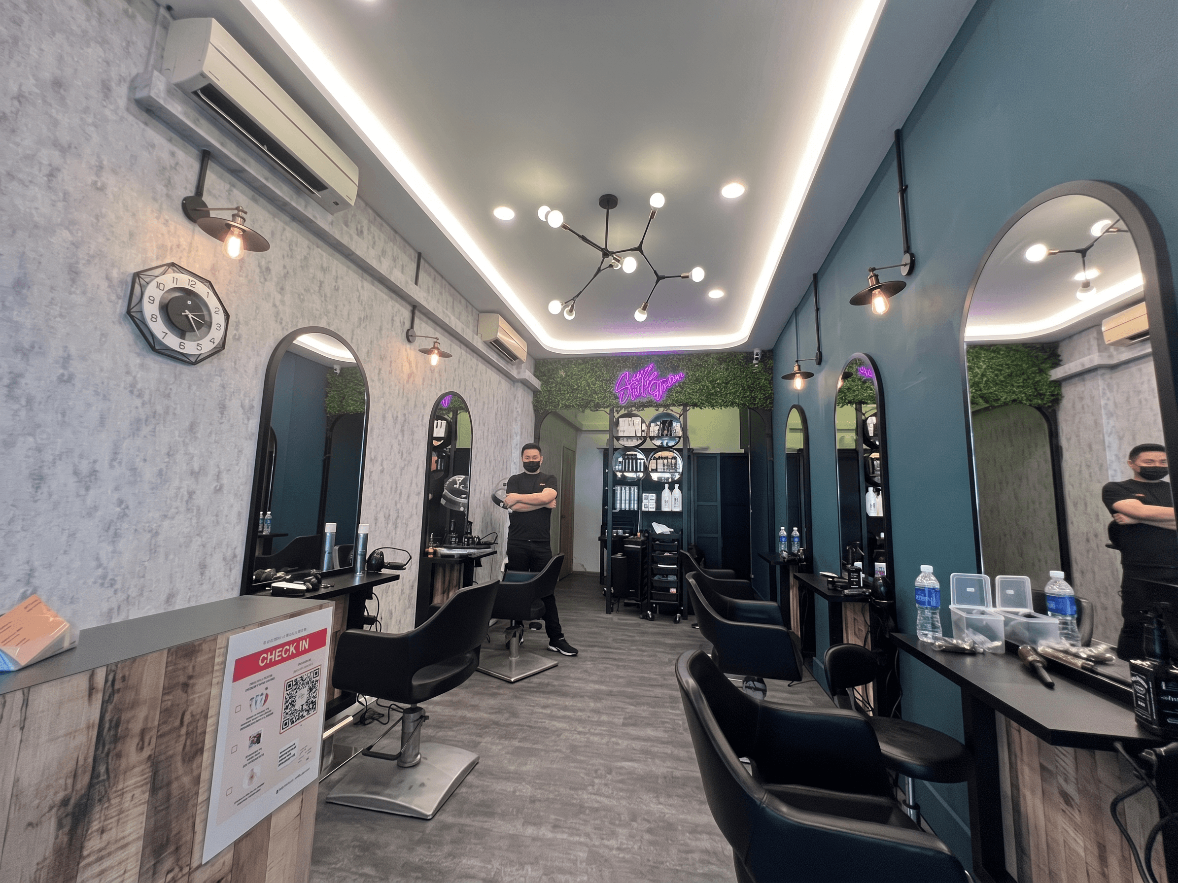 Eshco Hair Studio interior — arched mirrors, teal walls, warm lighting