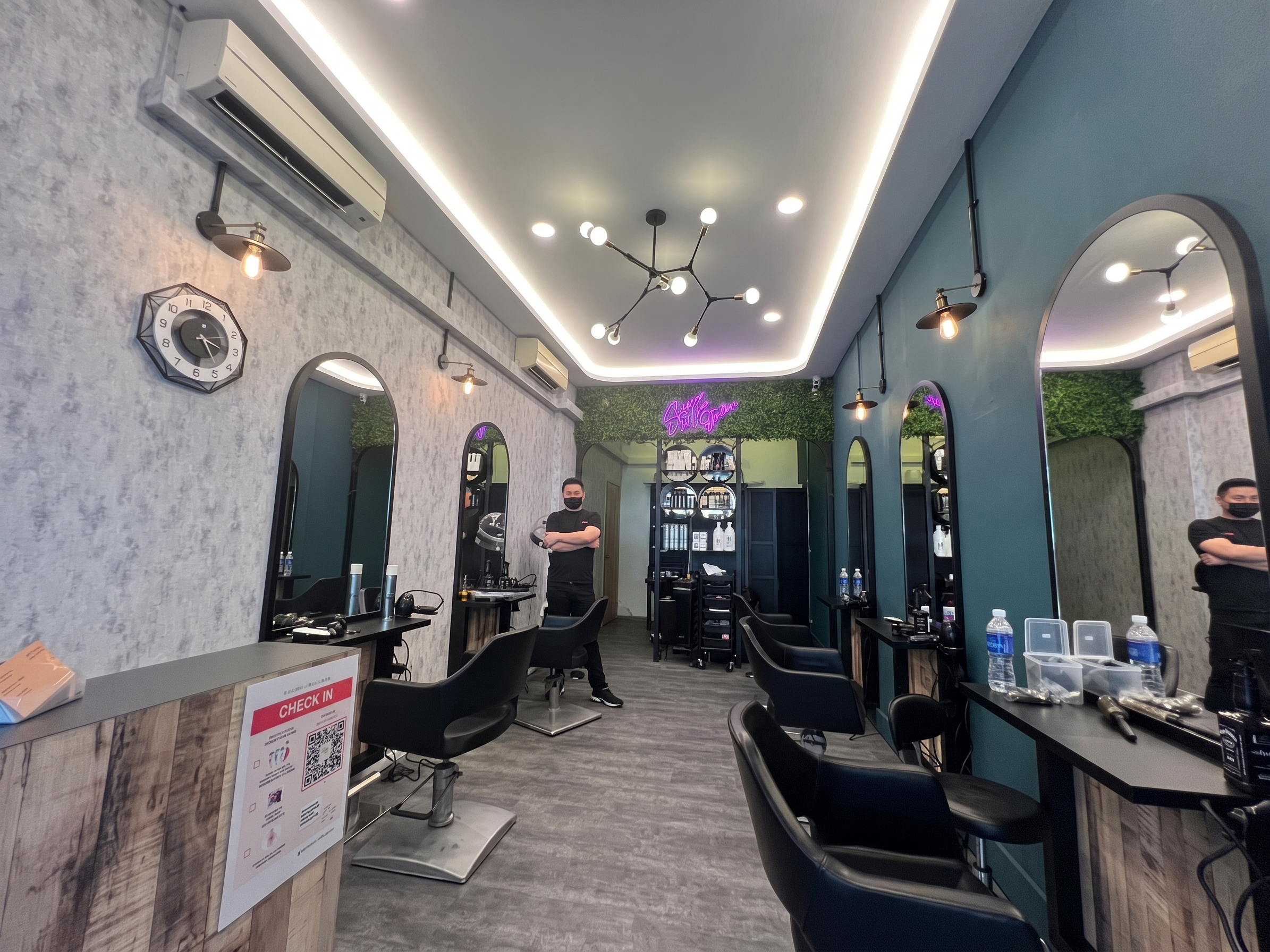 Eshco Hair Studio interior — arched mirrors, teal walls, warm lighting